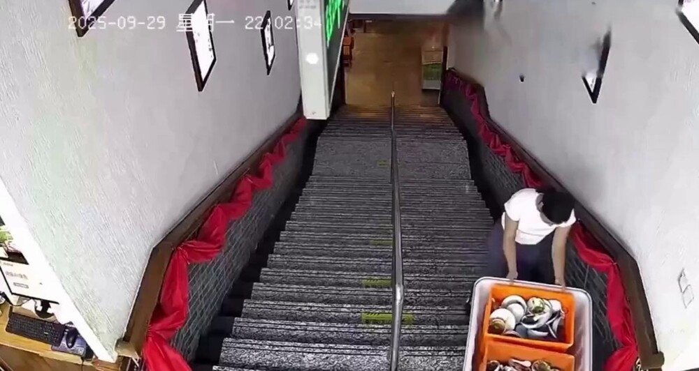 
        Попытка девушки спустить контейнер с&nbsp;посудой с&nbsp;лестницы    