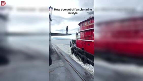 
        Мужчина шагает с&nbsp;подводной лодки на&nbsp;другой корабль в&nbsp;открытом море    